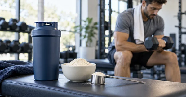 Batidor y proteína en polvo en un gimnasio durante un entrenamiento